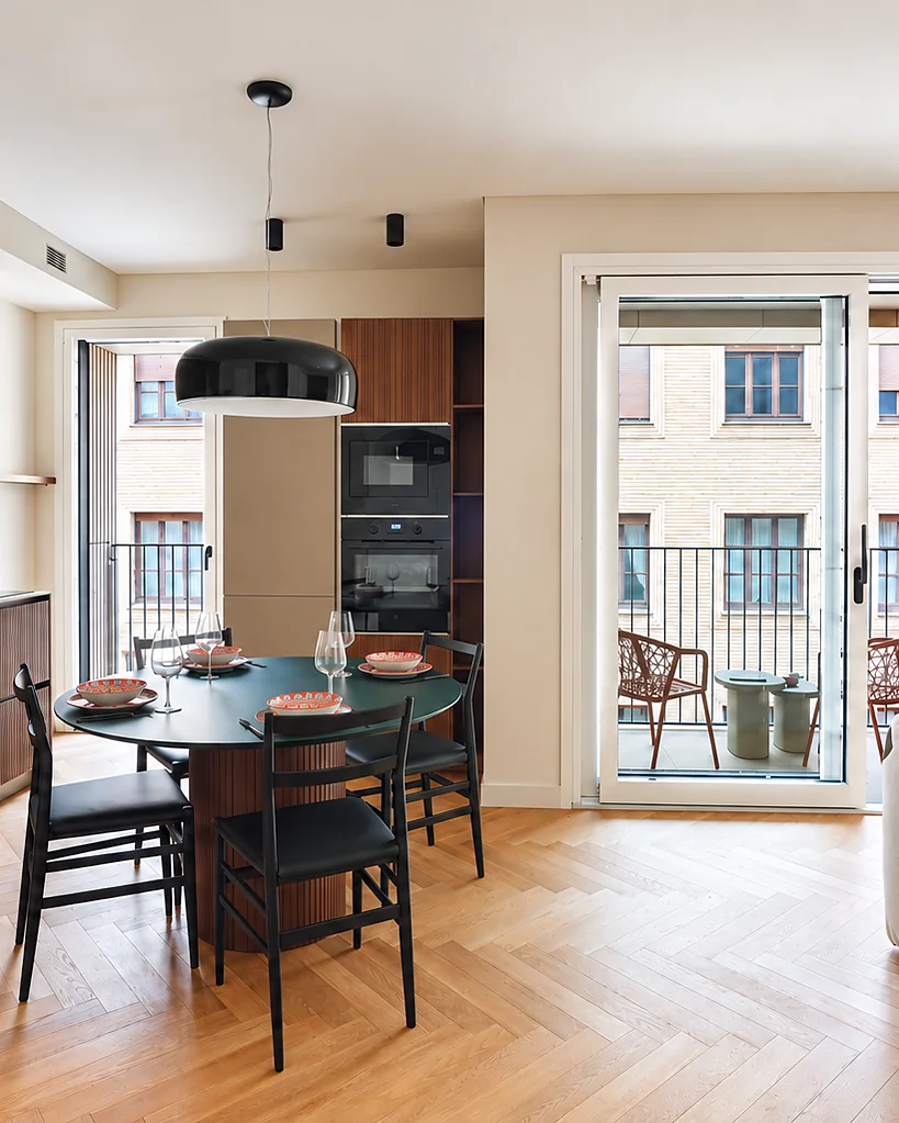 Zona pranzo con un tavolo scuro sotto una lampada a sospensione e la portafinestra sul balcone: Dune Terrace, Torino