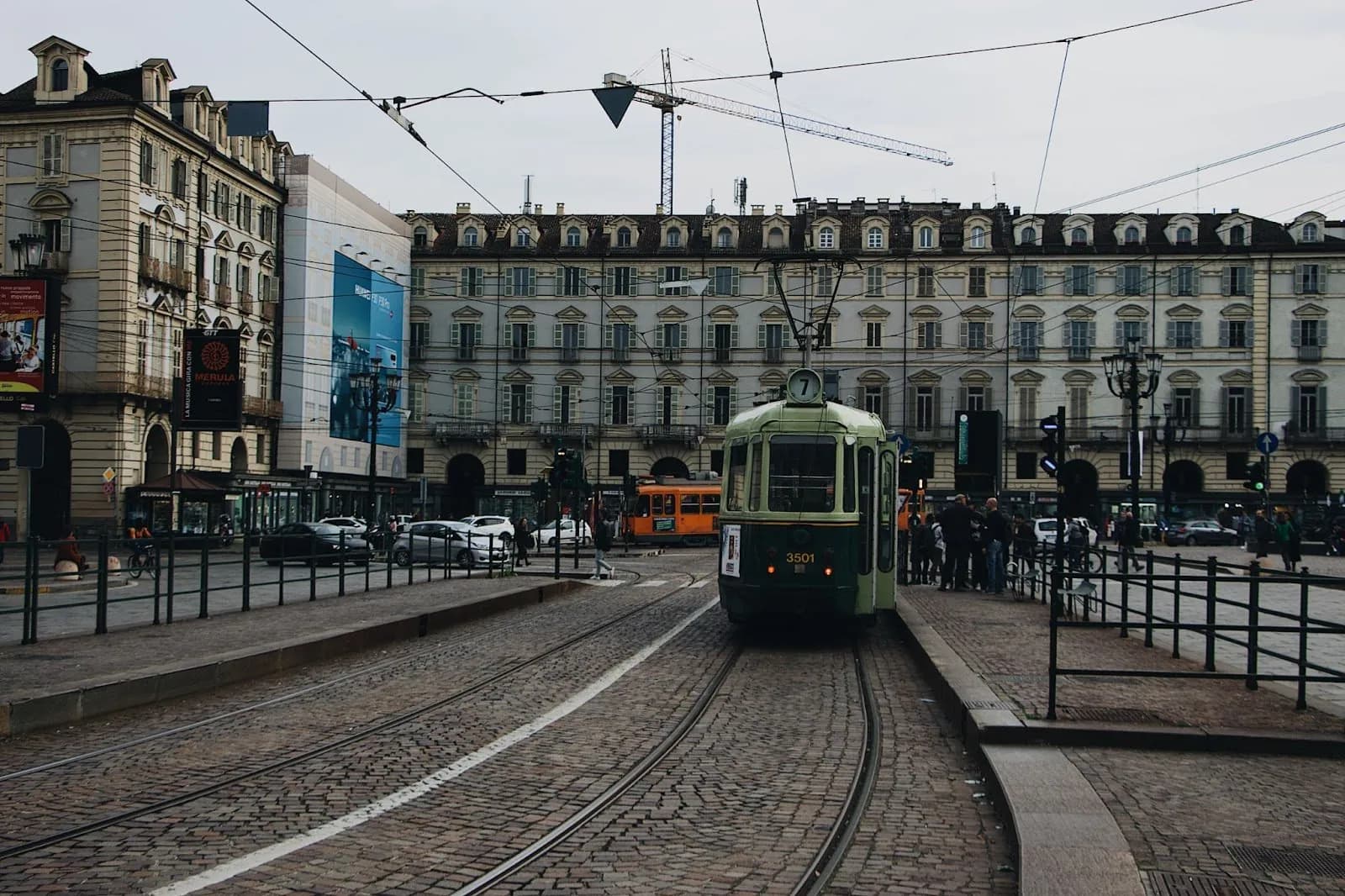 A historic line 7 tram in an arcaded square in the centre of Turin