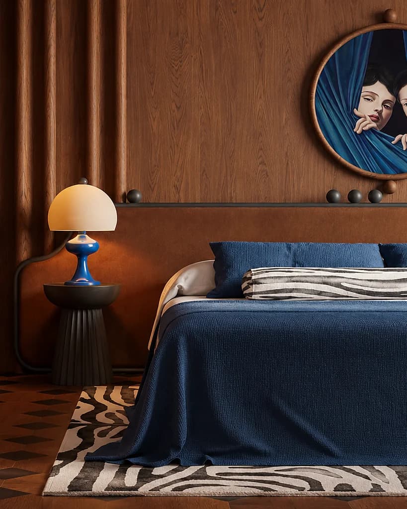 Una camera da letto con la parete rivestita in legno, un copriletto blu, una lampada da comodino dal paralume bianco e un tappeto a strisce bianche e nere
