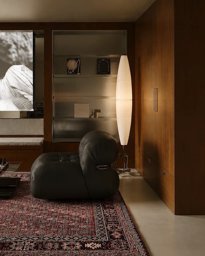 A living room with a black leather armchair, wood-panelled walls and a black-and-white film on the wall