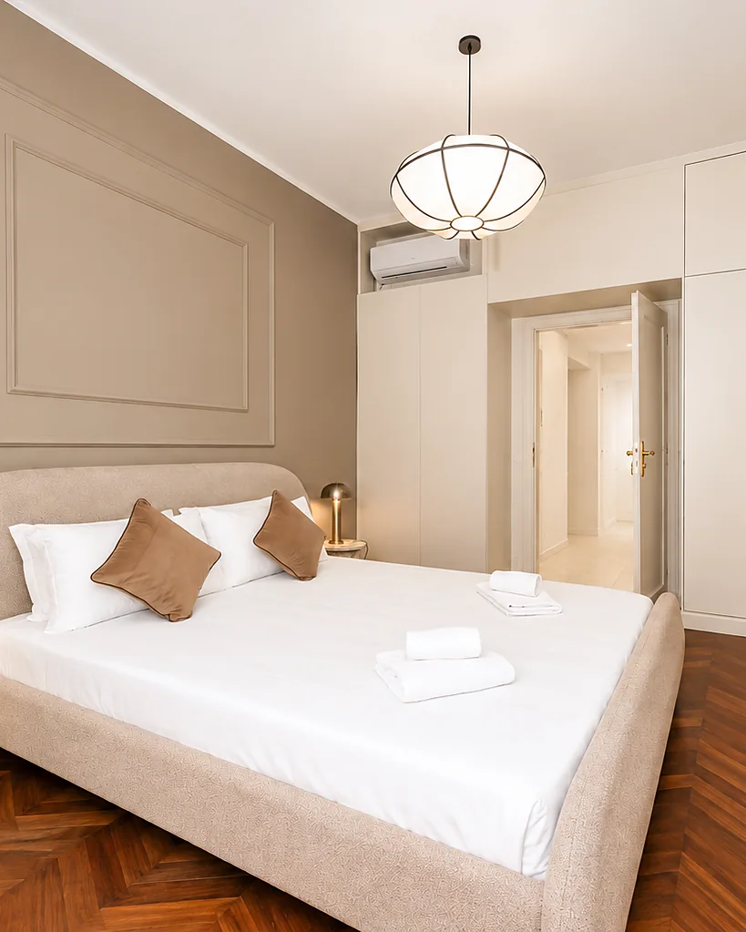 Bedroom with an upholstered headboard, panelled walls and herringbone parquet: Dimora Reale, Turin