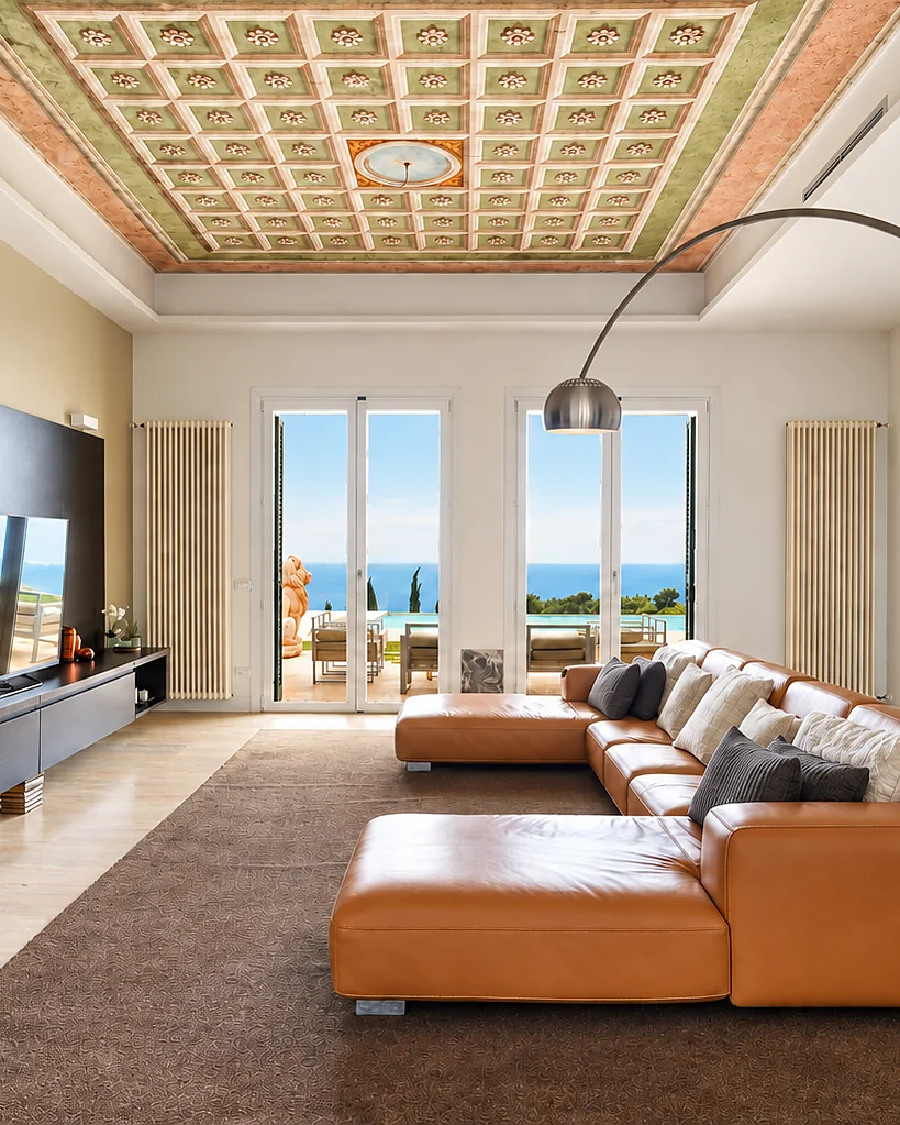 Living room with a leather sofa, a coffered ceiling and French windows onto the sea: Villa Cipressa, Liguria