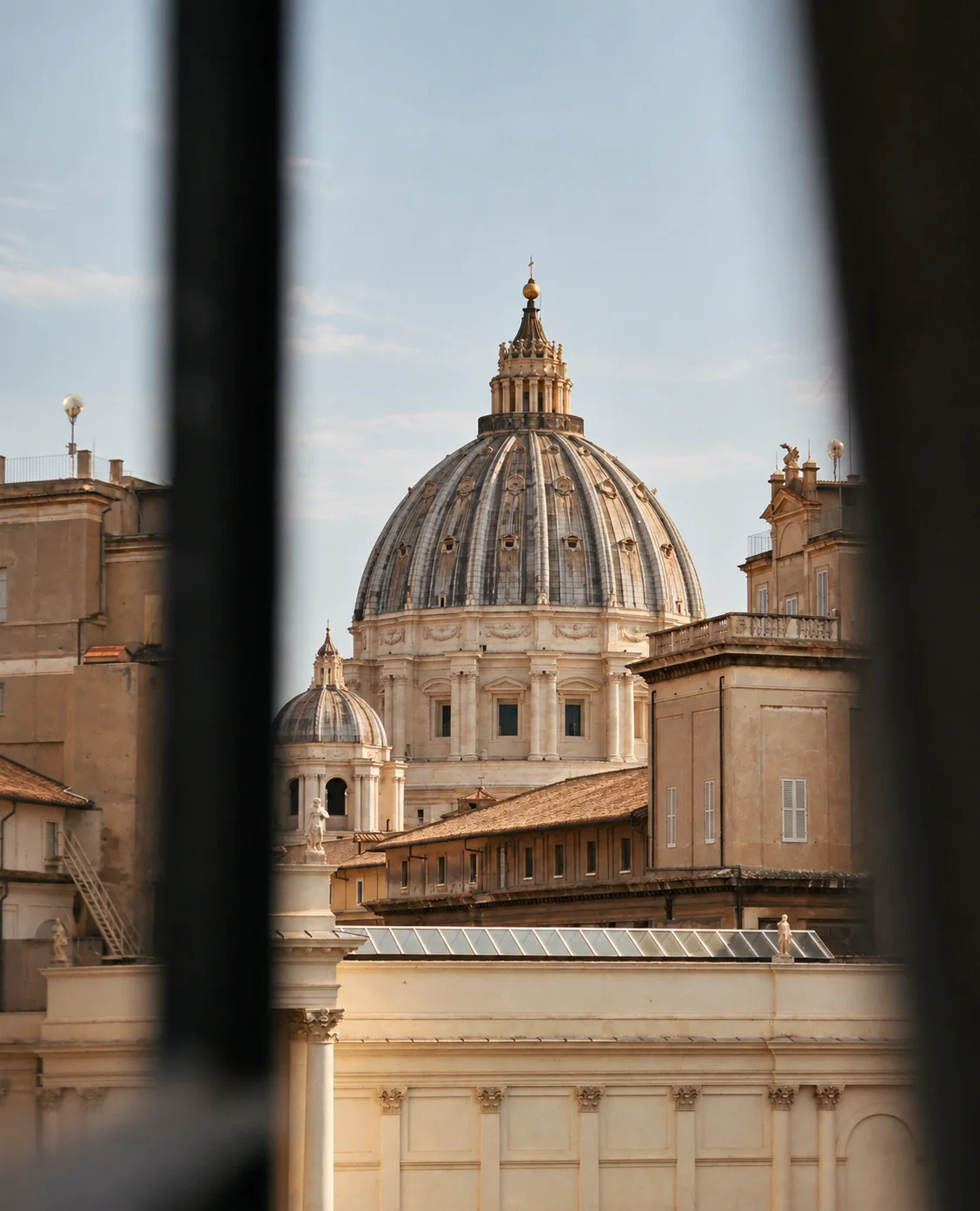La cupola di San Pietro vista da una finestra socchiusa, sopra i tetti di Roma