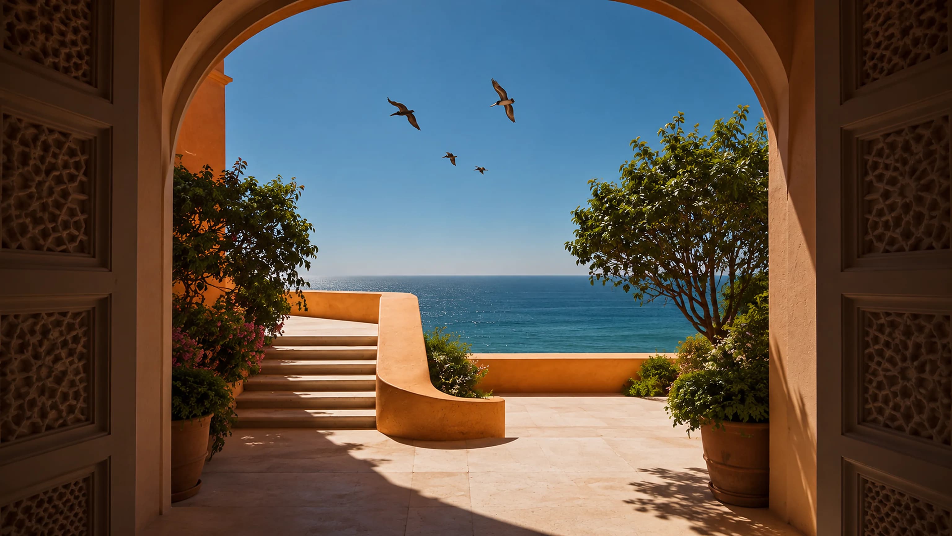 An arch opening onto the sea, with a curved bench, terracotta pots and swallows in the sky