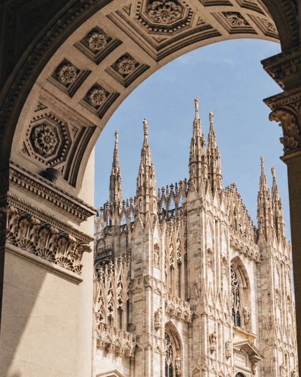 The spires of Milan Cathedral seen through an arch