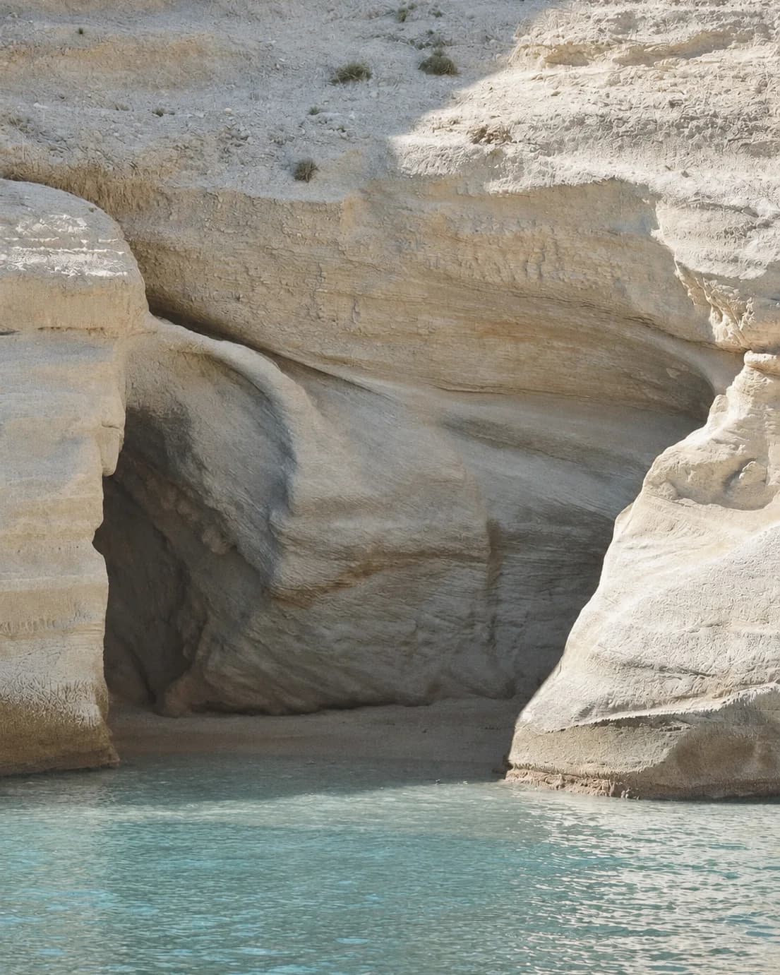 White rocks dropping into turquoise water, in Sicily