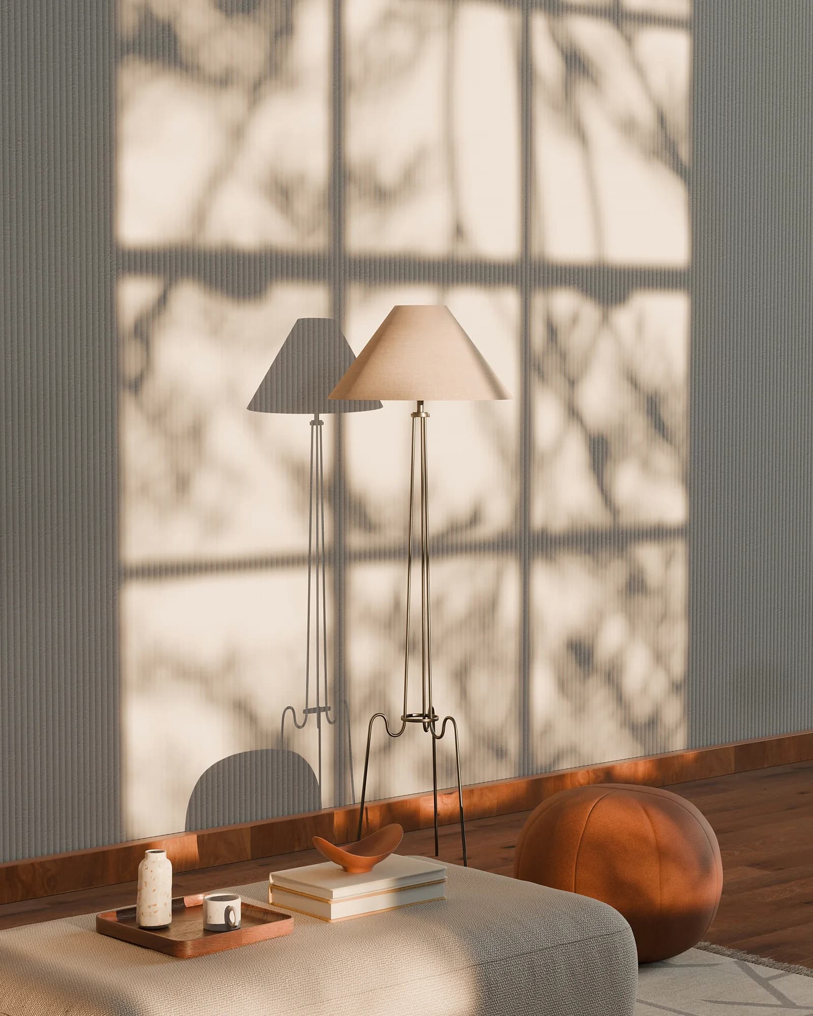Two floor lamps and a tray of objects in a pale room, with the shadow of branches on the wall