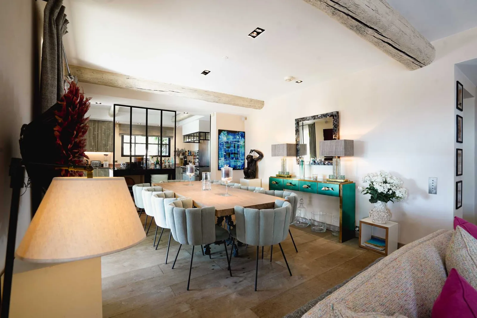 La zona pranzo di Villa Galli: un lungo tavolo con le sedie imbottite, le travi di legno e una consolle verde