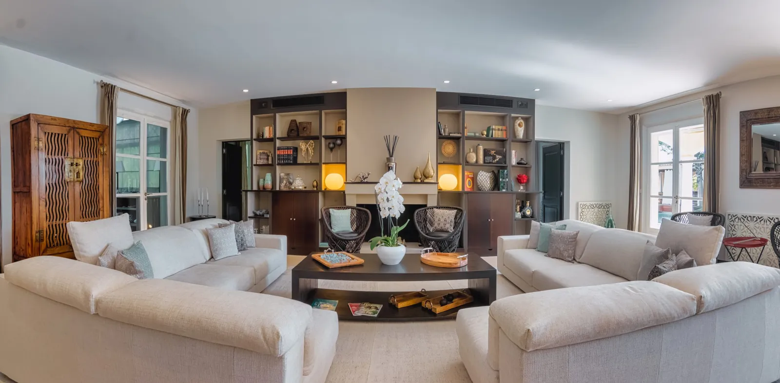 Il soggiorno di Villa Hollywood: due divani bianchi e una libreria illuminata alla parete