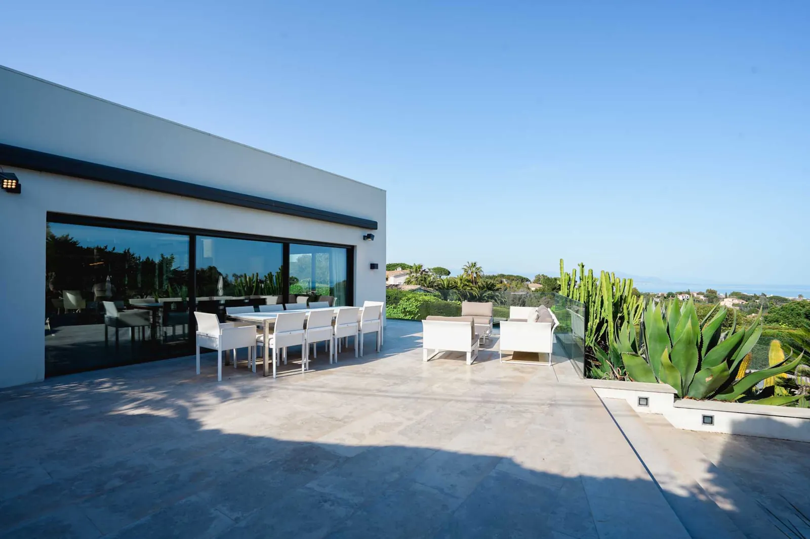 The living room at Villa Venere: a curved sofa, a marble floor and glass walls onto the view